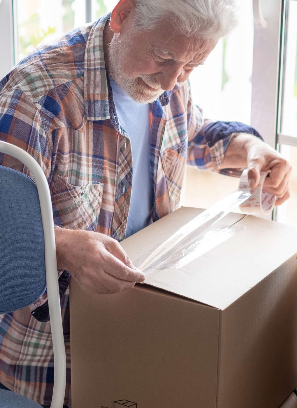 man packing a cardboard box